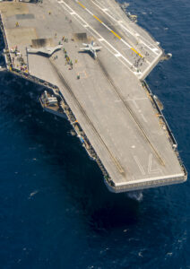 An unmanned X-47B and a manned F-18 Hornet side by side on the USS Roosevelt.