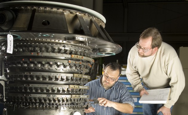 Technicians work on a Pratt & Whitney 2000 engine, used by both commercial and military aircraft.
