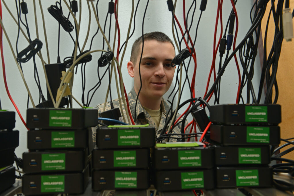 A communications technician behind wires.
