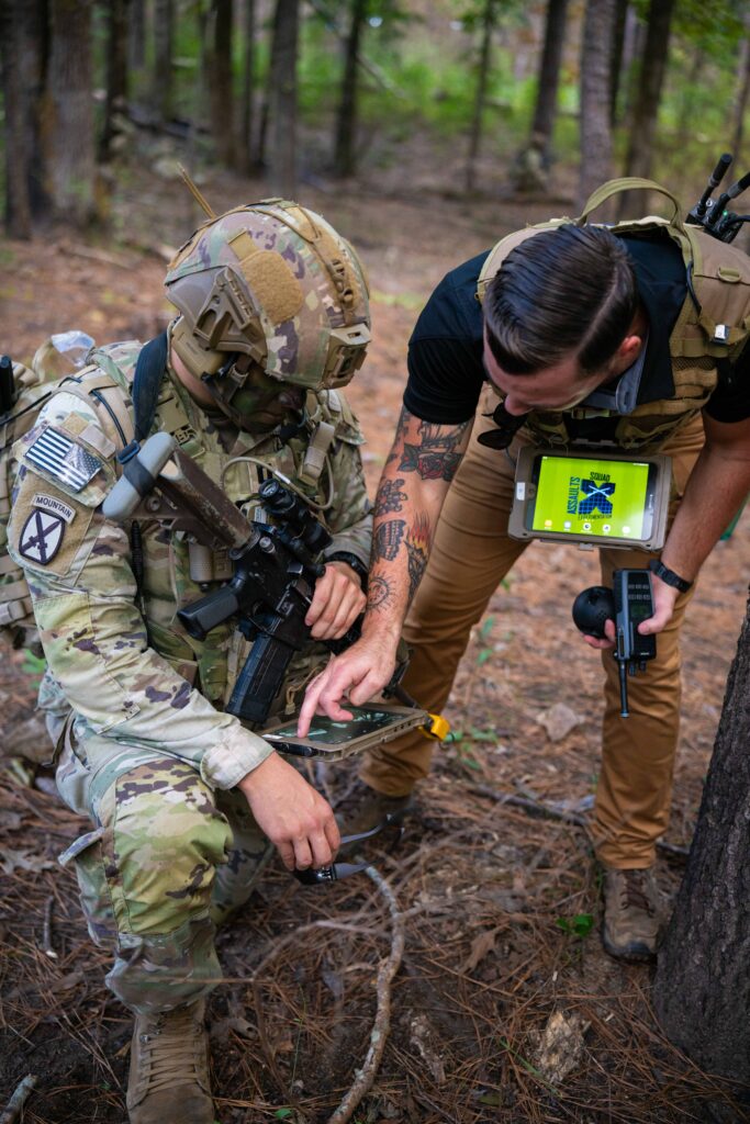Capt. Adam Rodriguez, the exercise platoon leader assigned to Alpha Company, 1st Battalion, 29th Infantry Regiment, receives additional guidance for using his tablet during the final exercise of the 10X Dismounted Infantry Platoon Project at Fort Moore, Georgia Sept. 20. 10X is led by the U.S. Army DEVCOM Ground Vehicle Systems Center in partnership with Fort Moore’s Robotics Requirements Division, the Maneuver Battle Lab, and the National Advanced Mobility Consortium, and is using a robotic system of systems integrated with an infantry platoon to enhance maneuver, situational awareness, and operational effectiveness (U.S. Army photo by Chris Estrada).