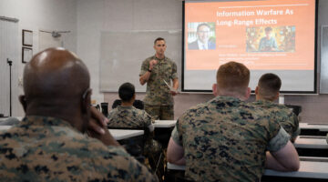A U.S. Marine with Joint Task Force-Ares introduces Ryan McBeth, an open-source intelligence analyst and cybersecurity expert, before a professional military education session at Fort George G. Meade, Maryland, July 23, 2026. (U.S. Marine Corps photo by Sgt. Isaiah W. Smith)