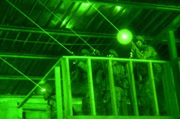 Army soldiers training with laser sights and night vision devices.
