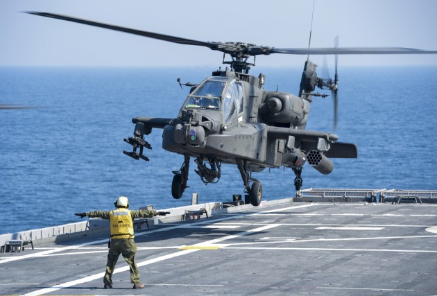 A US Army Apache helicopter lands on a Navy ship in the Persian Gulf region.