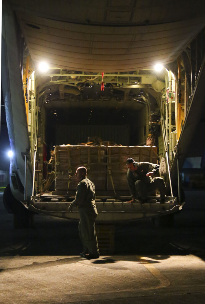 Marines unload Meals Ready To Eat (MREs) at a Philippine air base.