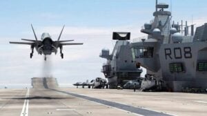 A computer-generated image of a Royal Navy F-35B taking off vertically from the new carrier HMS Queen Elizabeth, which will be commissioned July 4th.