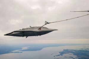 The experimental X-47B drone plugs into an aerial refueling tanker for the first time.