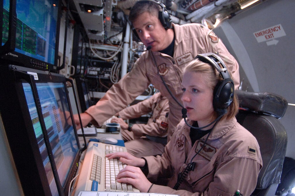 Lt. Col. Doug Sachs and 1st Lt. Beth Brockshus monitor equipment that scans the earth to detect, identify and geolocate signals throughout the electromagnetic spectrum on board an RC-135 Rivet Joint. The two are electronic warfare officers and are two of 34 crew members who fly aboard the RC-135. The crew can forward information in a variety of formats to a wide range of consumers via the plane's extensive communications suite. Colonel Sachs is deployed from Kadena Air Base, Japan, as the 763rd Expeditionary Reconnaissance Squadron commander, and Lieutenant Brockshus is deployed from Offutt Air Force Base, Neb. (U.S. Air Force photo/Master Sgt. Scott Wagers)