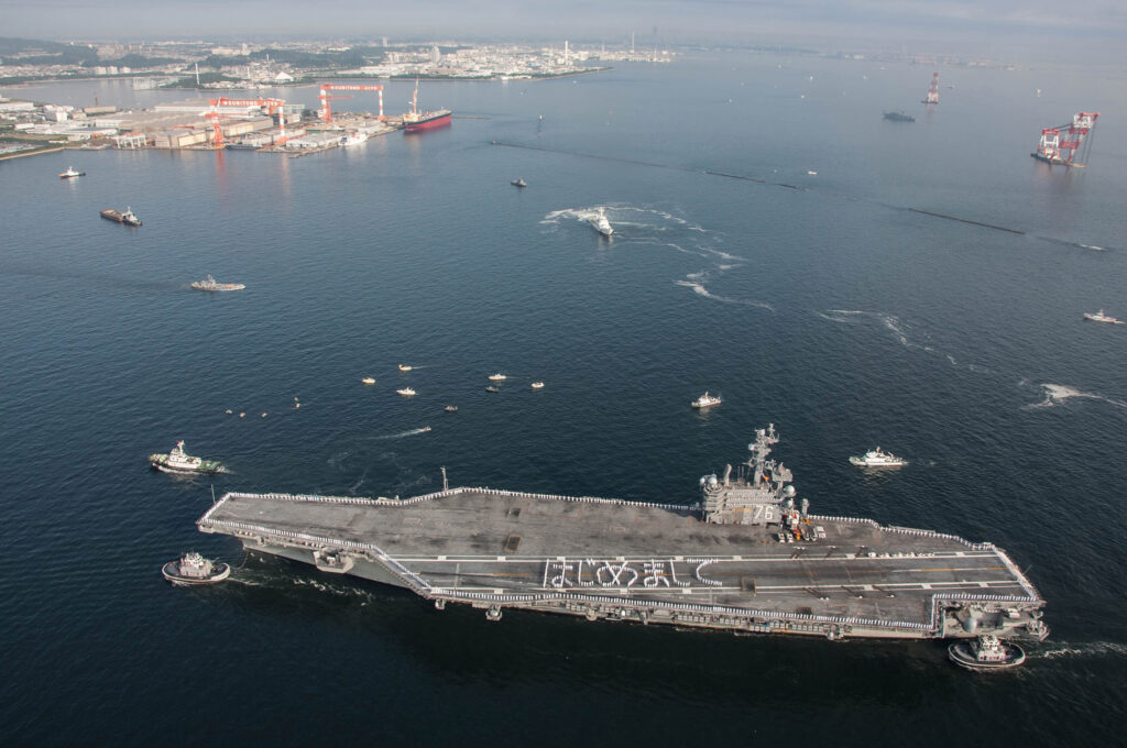 The carrier USS Ronald Reagan arrives at its new base in Yokosuka, Japan, replacing the USS George Washington.