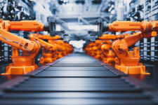 Robotic arms along assembly line in modern factory.